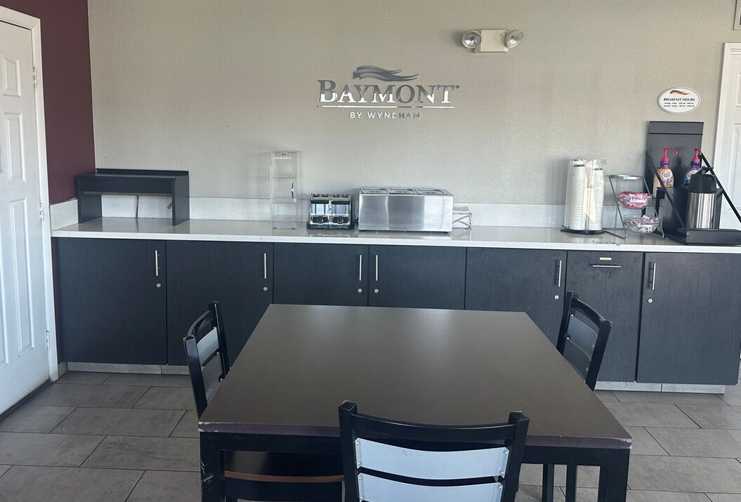 A kitchen with a Baymont logo, a coffee machine, a toaster, and a refrigerator.