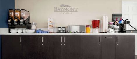 A modern kitchen with a Baymont by Wyndham logo, a coffee machine, a toaster, and various kitchen appliances.