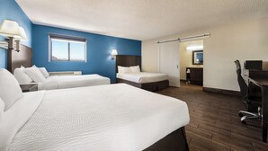 A hotel room with two beds, a desk, a chair, a window, and a bathroom visible through an open door. - Baymont by Wyndham Kingman (Kingman)