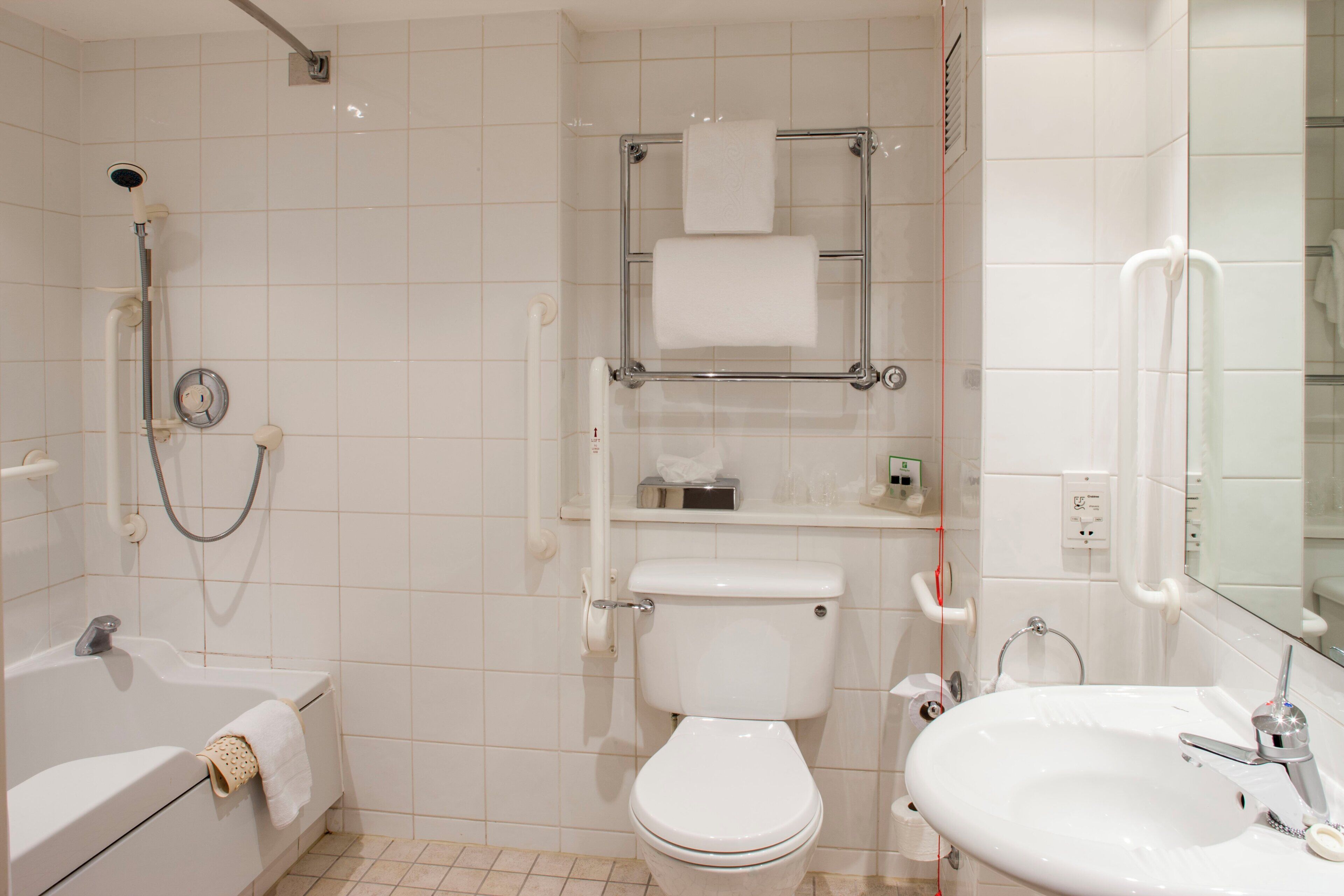 A bathroom with a bathtub, toilet, and sink.