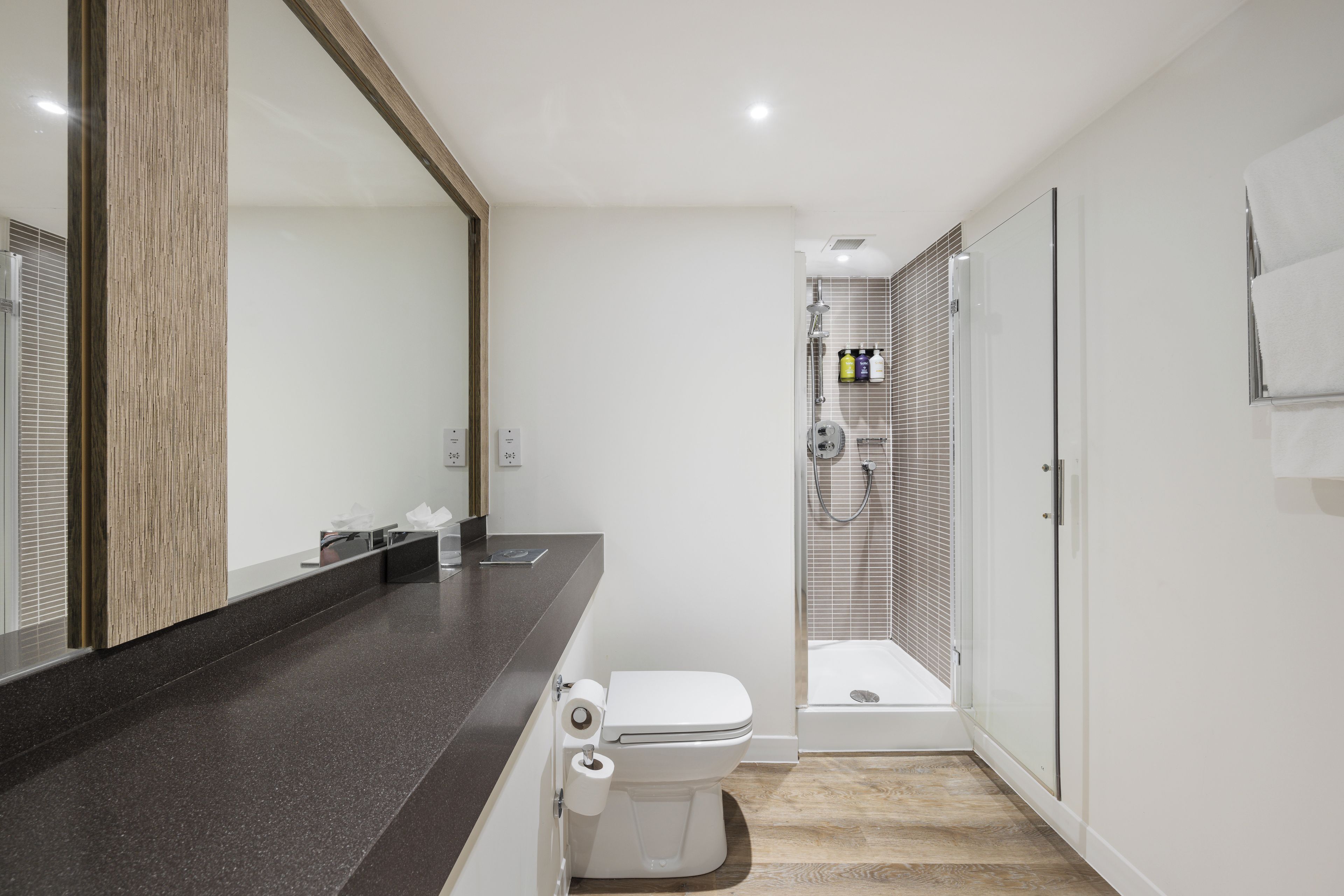Un baño moderno con inodoro, lavamanos y ducha.