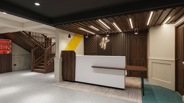 A reception area with a modern desk, a staircase, and a wooden ceiling. - Holiday Inn Ashford Central by IHG (Ashford)