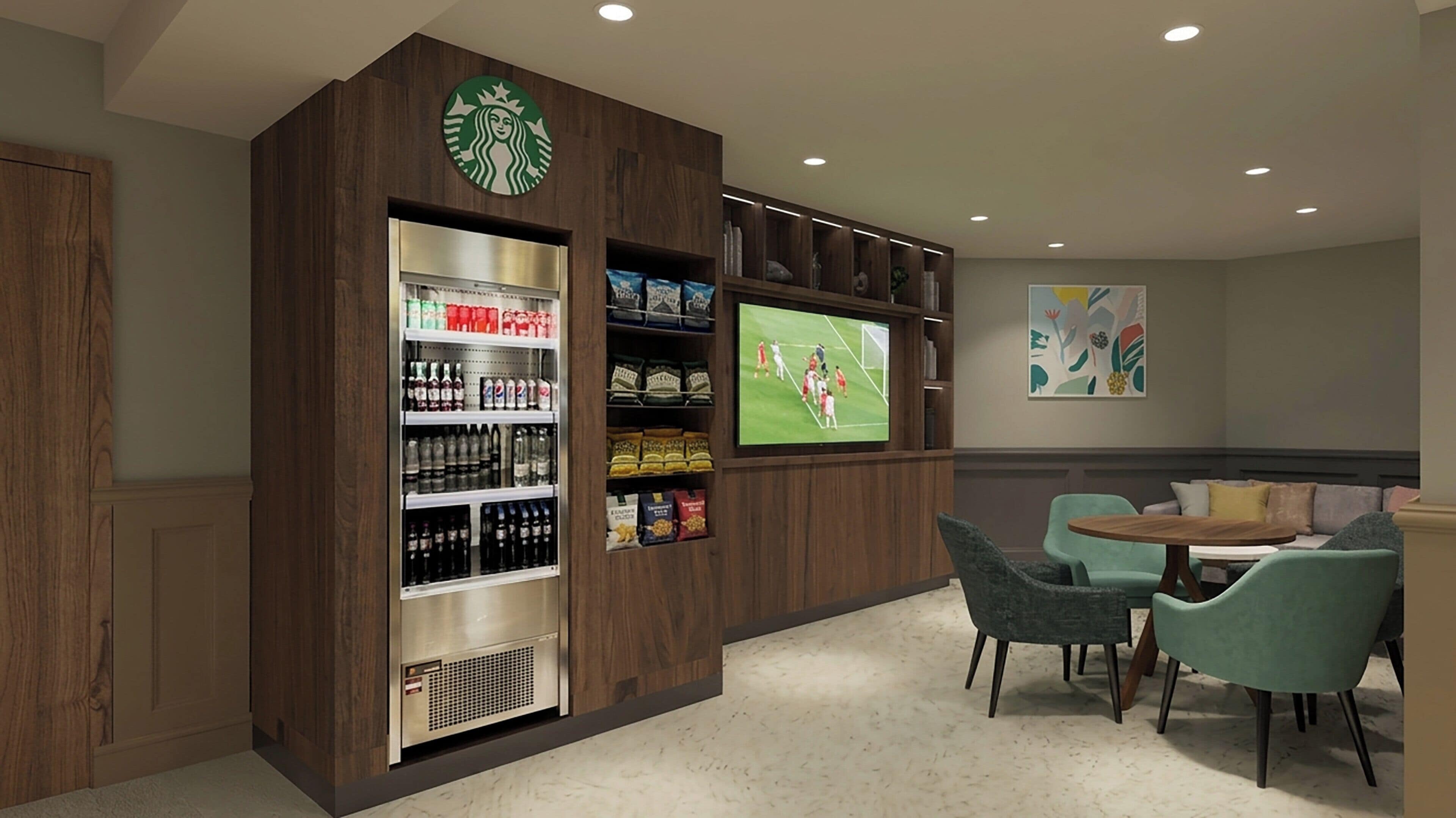 Habitación con cafetera, estantes con aperitivos, televisor y zona de estar.