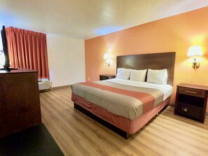 A hotel room with a large bed, two bedside tables, a desk, and a chair. - Motel 6 Levittown, PA - Bensalem (Levittown)