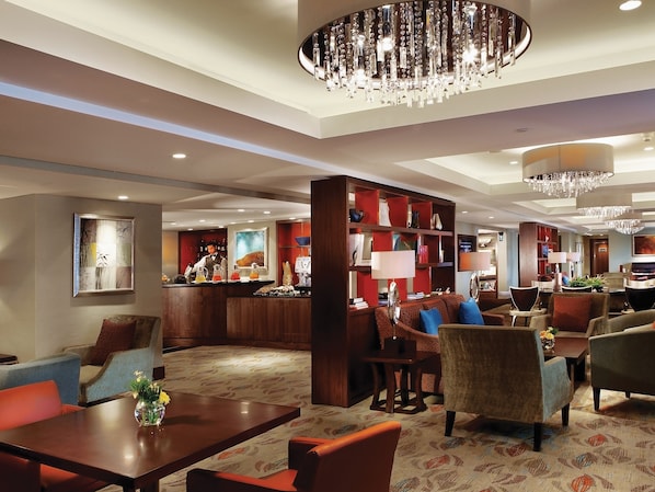 A hotel lobby with a bar, seating area, and a chandelier. - Shangri-La Jakarta (Jakarta)