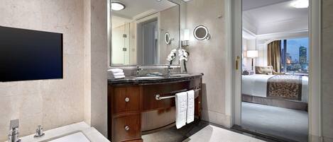 Un baño moderno con un espejo grande, una bañera y un tocador con un perchero.