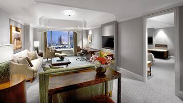 A modern hotel room with a city view, a dining area, and a living room with a large window.