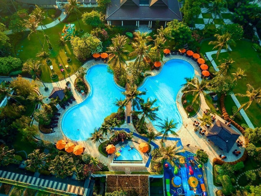 Una piscina al aire libre, sombrillas, tumbonas