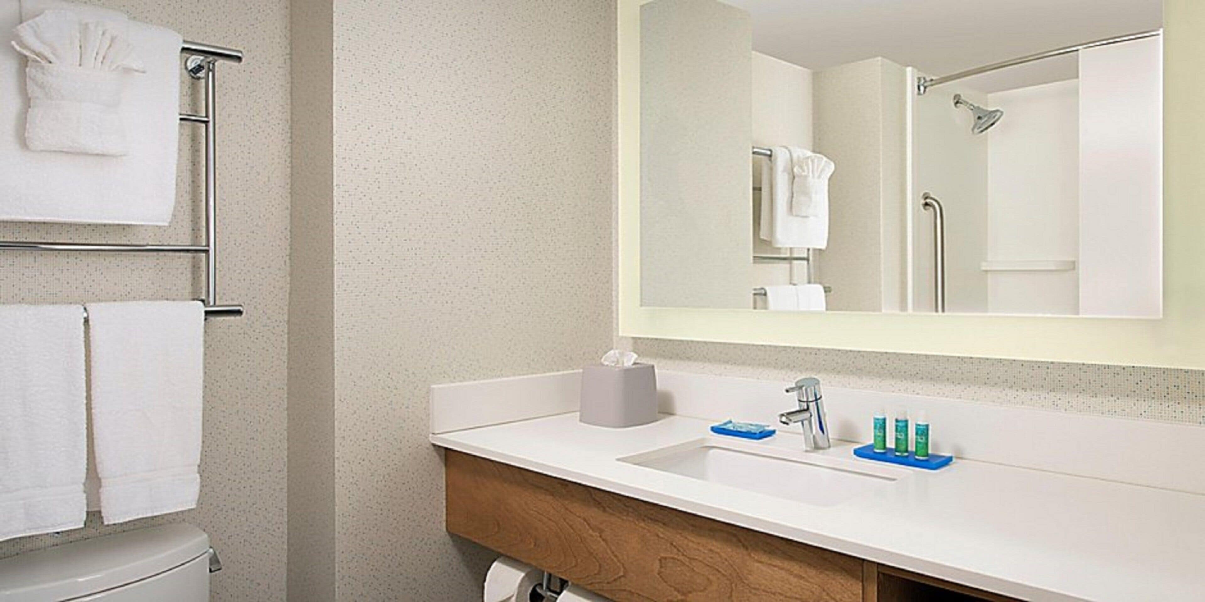Une salle de bain avec un lavabo blanc, un miroir et un porte-serviettes.
