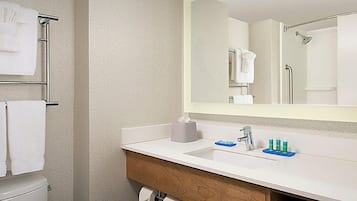 Une salle de bain avec un lavabo blanc, un miroir et un porte-serviettes.