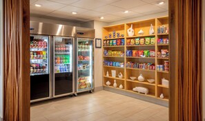 A snack and beverage vending area with multiple shelves stocked with various products. - Holiday Inn Express Chesapeake - Norfolk by IHG (Chesapeake)