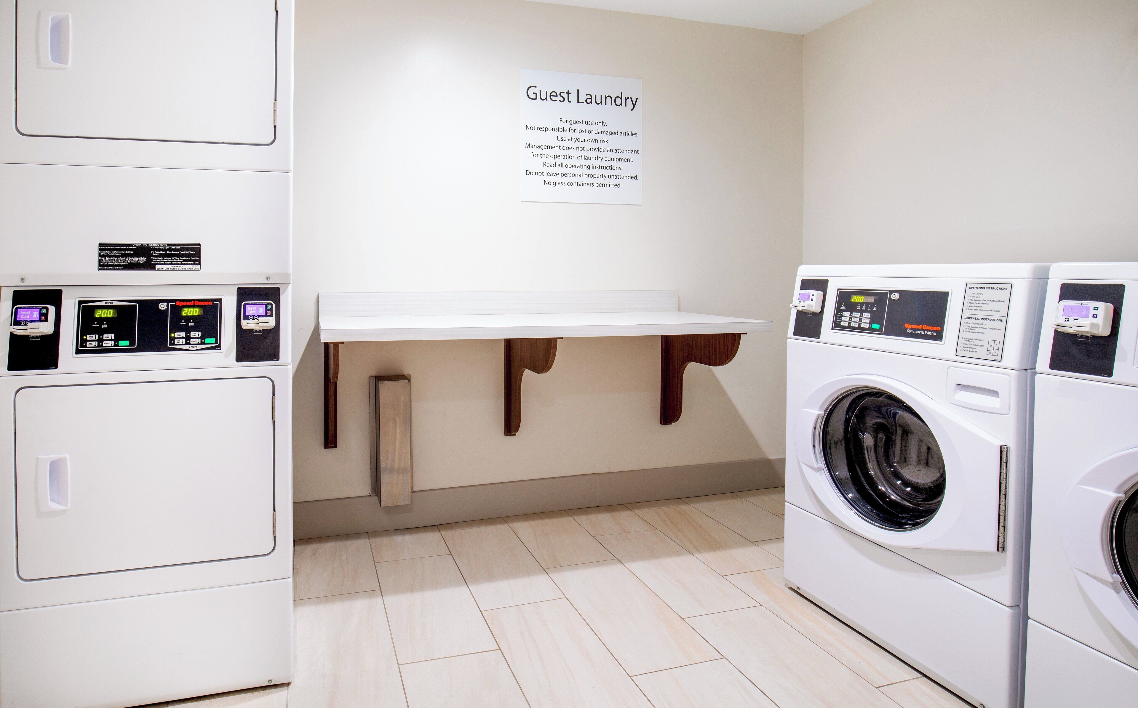 A laundry area with a sign indicating it's for guest use only, a washing machine, and a dryer.