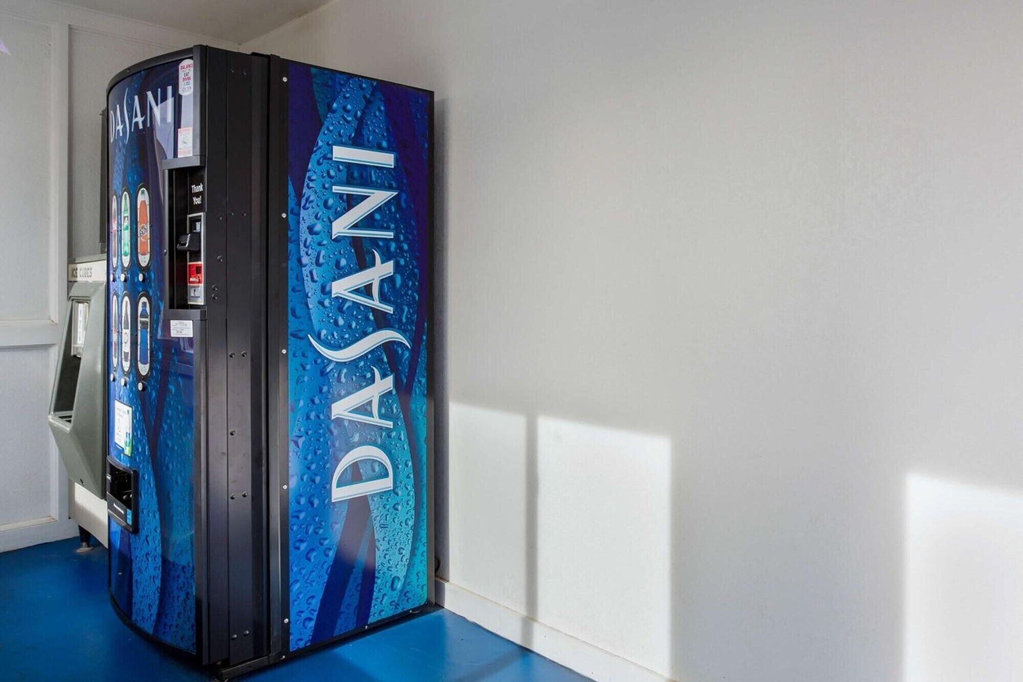 A DASANI water dispenser in a room with a blue floor and white walls.