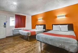 A hotel room with two beds, a wooden floor, an air conditioning unit, and a window with red curtains. - Motel 6 Clovis, NM (Clovis)