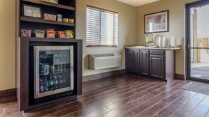 A kitchen with a refrigerator, a window with blinds, a microwave, and a sink. - Quality Inn Hays I-70 (Hays)