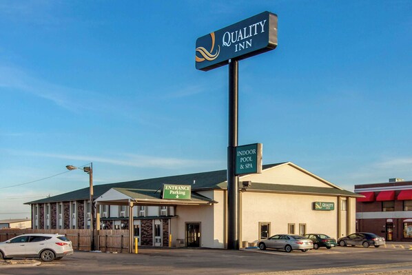 A Quality Inn with a sign indicating indoor pool and spa, and a sign for entrance parking.