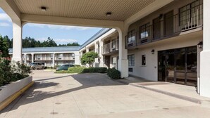 A hotel with a covered outdoor area, multiple balconies, and a parking lot. - Econo Lodge Grenada (Grenada)