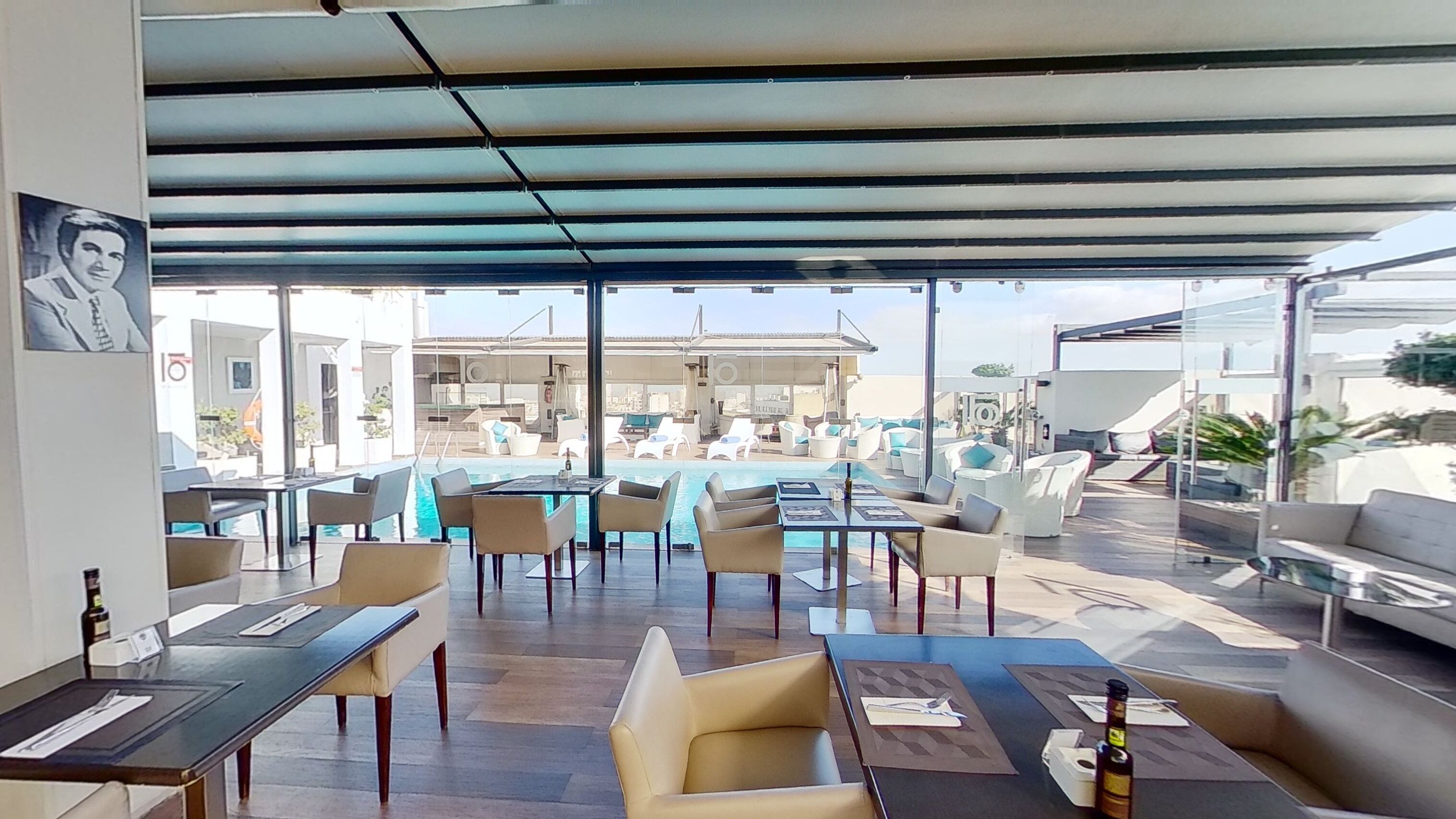Un bar situé sur le toit, avec une terrasse, une piscine et une vue panoramique sur la ville.
