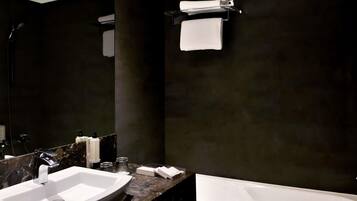 Un baño moderno con un lavamanos grande, una bañera y un espejo.