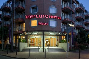 Un hotel con un letrero llamativo que dice 'Mercure Hotel Messe'.