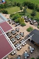 Un'area patio esterna con diversi posti a sedere, una zona riparata e un prato.