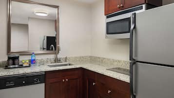 A modern kitchen with granite countertops, stainless steel appliances, and wooden cabinets.