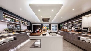 A modern kitchen with a central island, built-in appliances, and ample counter space. - Radisson Blu Hotel, Edinburgh City Centre (Edinburgh)