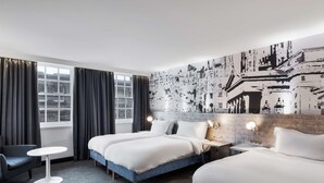 A hotel room with two beds, a small round table, a chair, and a large wall mural. - Radisson Blu Hotel, Edinburgh City Centre (Edinburgh)