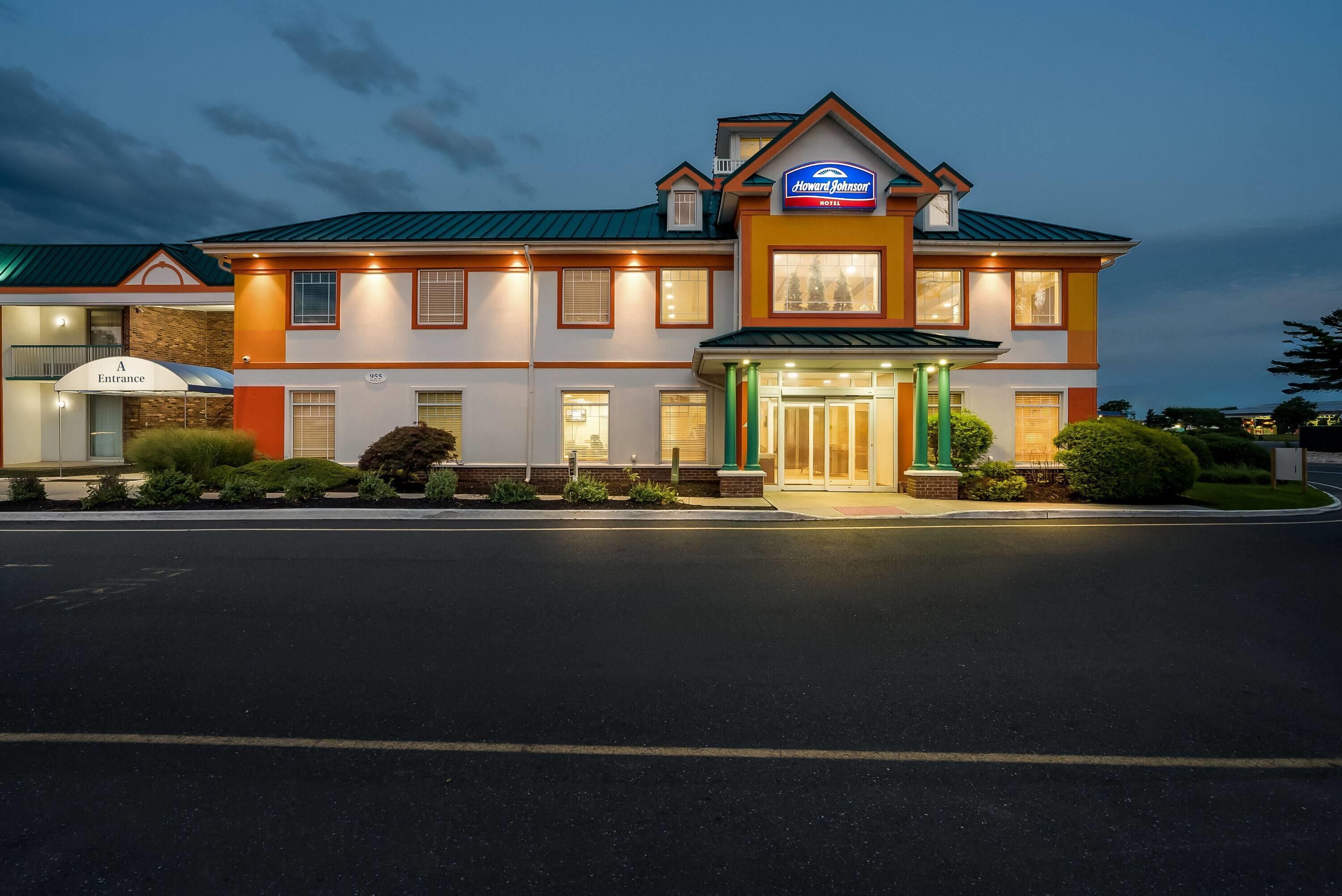 A Howard Johnson Hotel with a two-story structure, a covered entrance, and a well-lit facade.