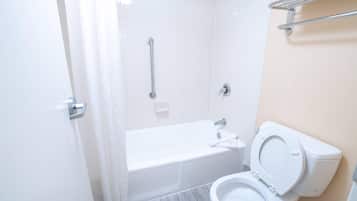 A modern bathroom with a bathtub, toilet, and shower.
