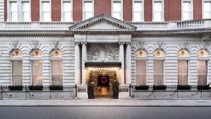A classical building with a grand entrance, large windows, and a prominent circular emblem at the center. - The London EDITION (London)