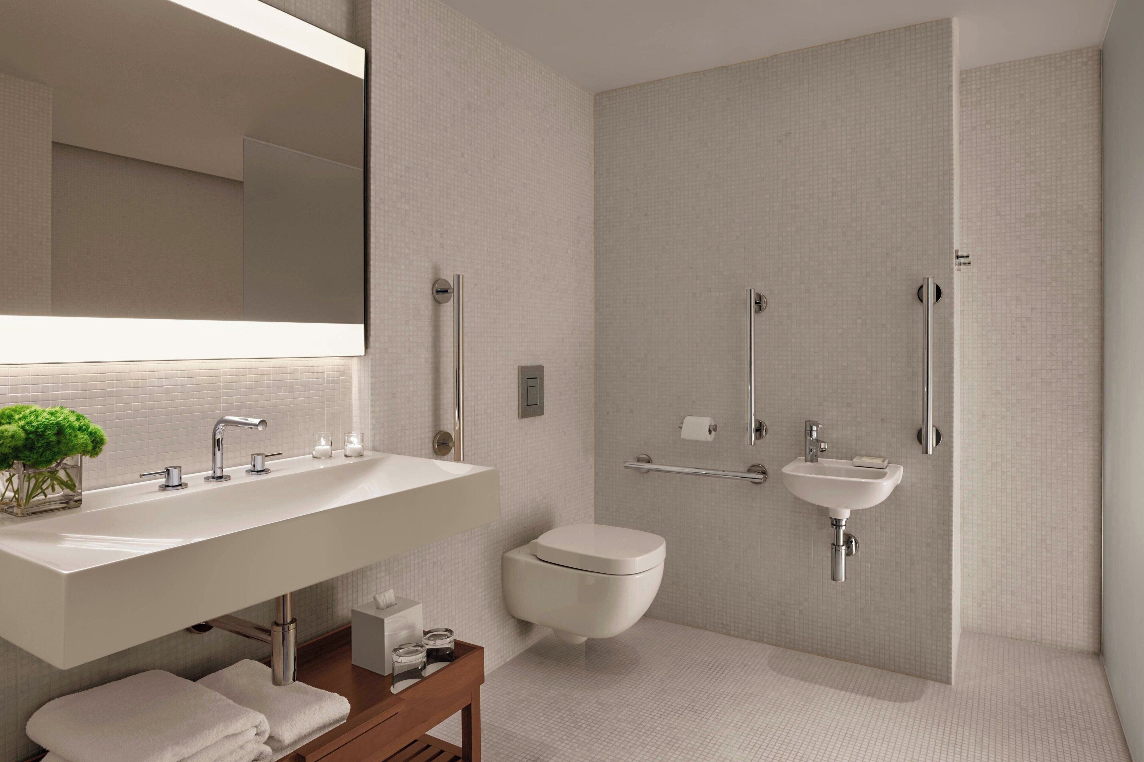 Un baño moderno con un lavamanos grande, inodoro, zona de ducha y espejo.
