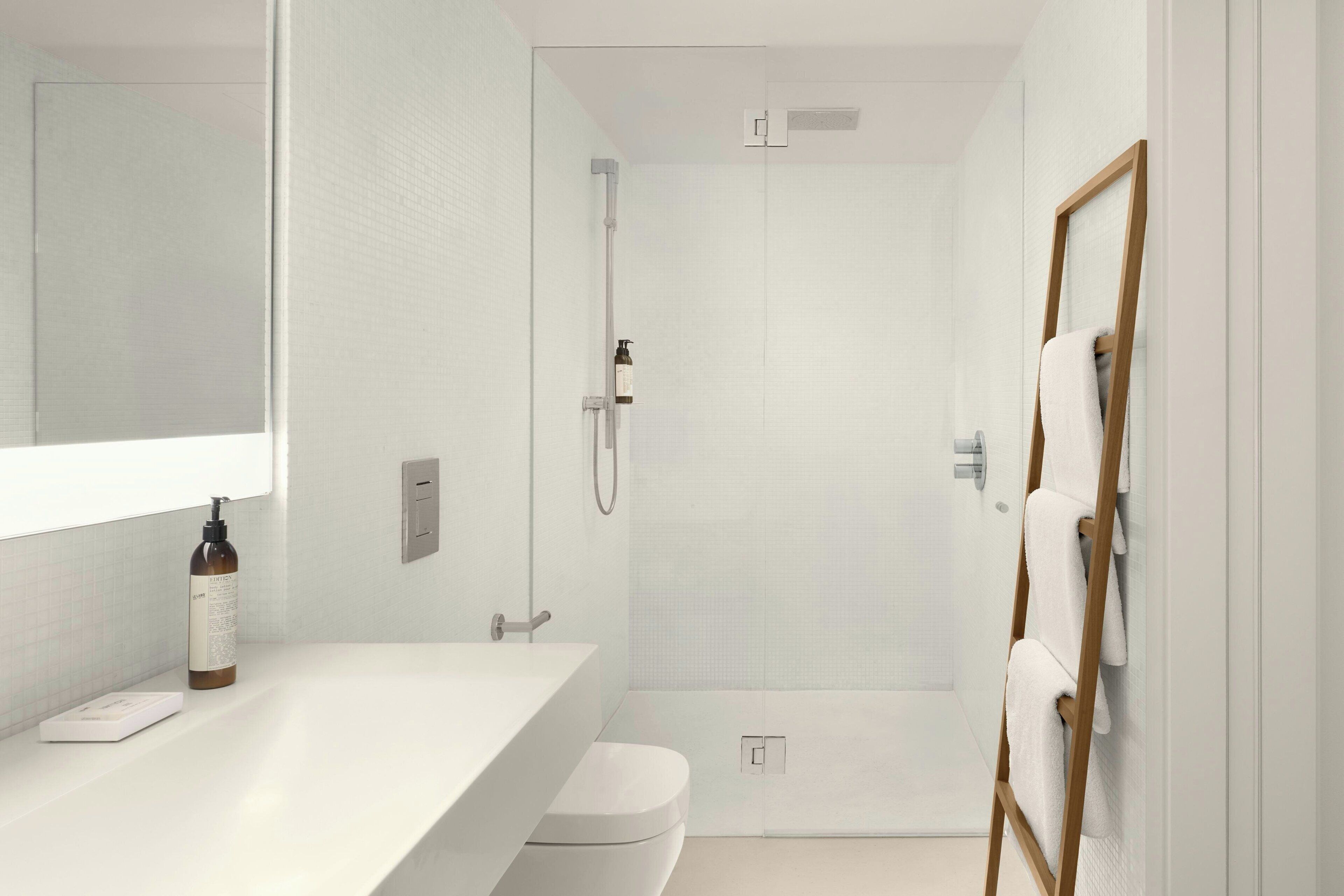 A modern bathroom with a white sink, toilet, and shower area.