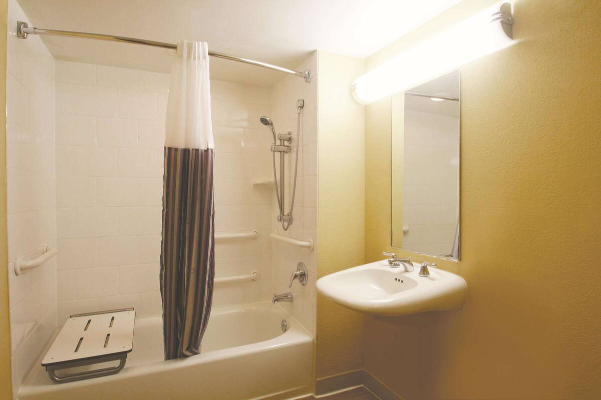 A bathroom with a bathtub, shower, and sink.