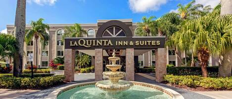 El letrero del hotel La Quinta Inn & Suites con una fuente en primer plano.