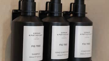 Three black bottles of Urban Apothecary Fig Tree products on a tiled wall.