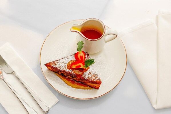 A plate with a dessert, a cup of tea, and a napkin.