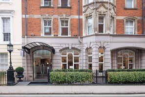 A traditional building with a brick facade, large arched windows, and a gated entrance. - Radisson Blu Hotel, London Tottenham Court Road (London)