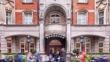 A building with a central entrance, multiple windows, and a sign indicating it's a hotel.