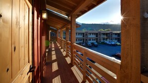 A wooden balcony with a view of a parking lot and buildings in the distance. - Cousins Country Inn (The Dalles)