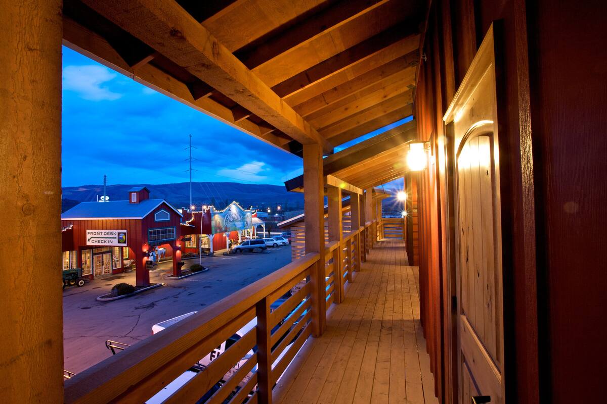 Un balcone in legno con vista su una piazza al crepuscolo.