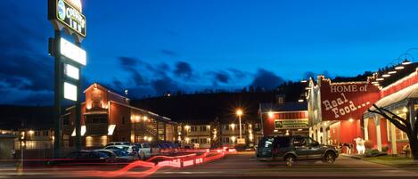 A hotel with a prominent sign, a front desk, and a building with a large sign advertising 'HOME of Real Food...'.