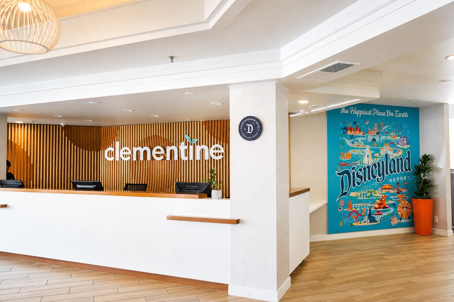 Una reception con un pannello in legno, un logo e un'indicazione per Disneyland Resort.