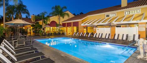 Una piscina al aire libre, una piscina climatizada, sombrillas