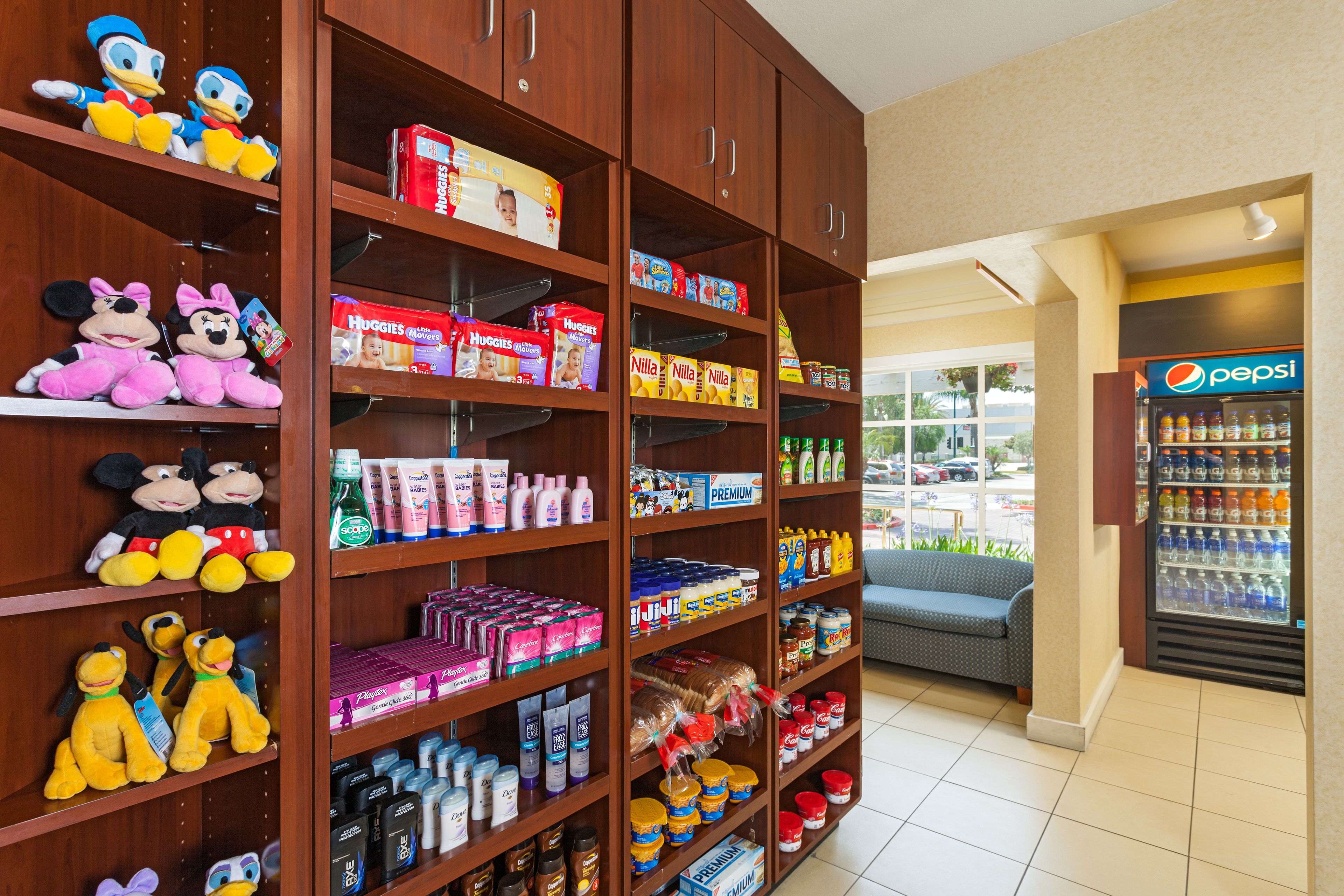 A store with shelves stocked with various products including toys, diapers, and beverages.