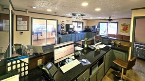 A restaurant with a counter, a computer, a phone, and a coffee machine.