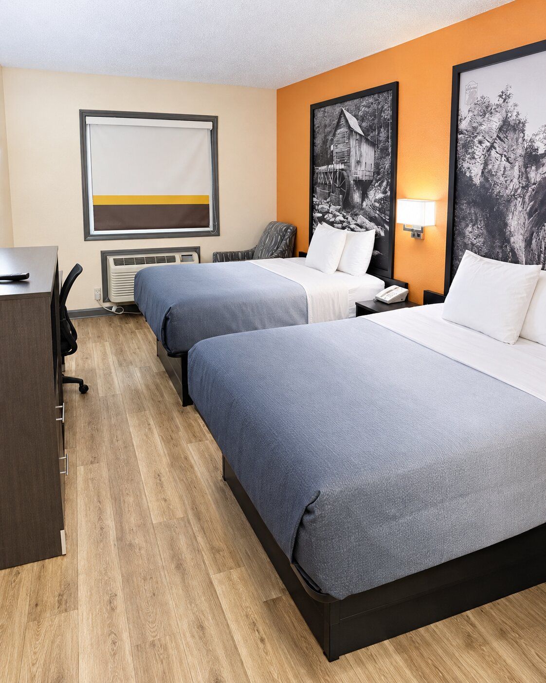 Una habitación de hotel con dos camas, un escritorio y una silla.