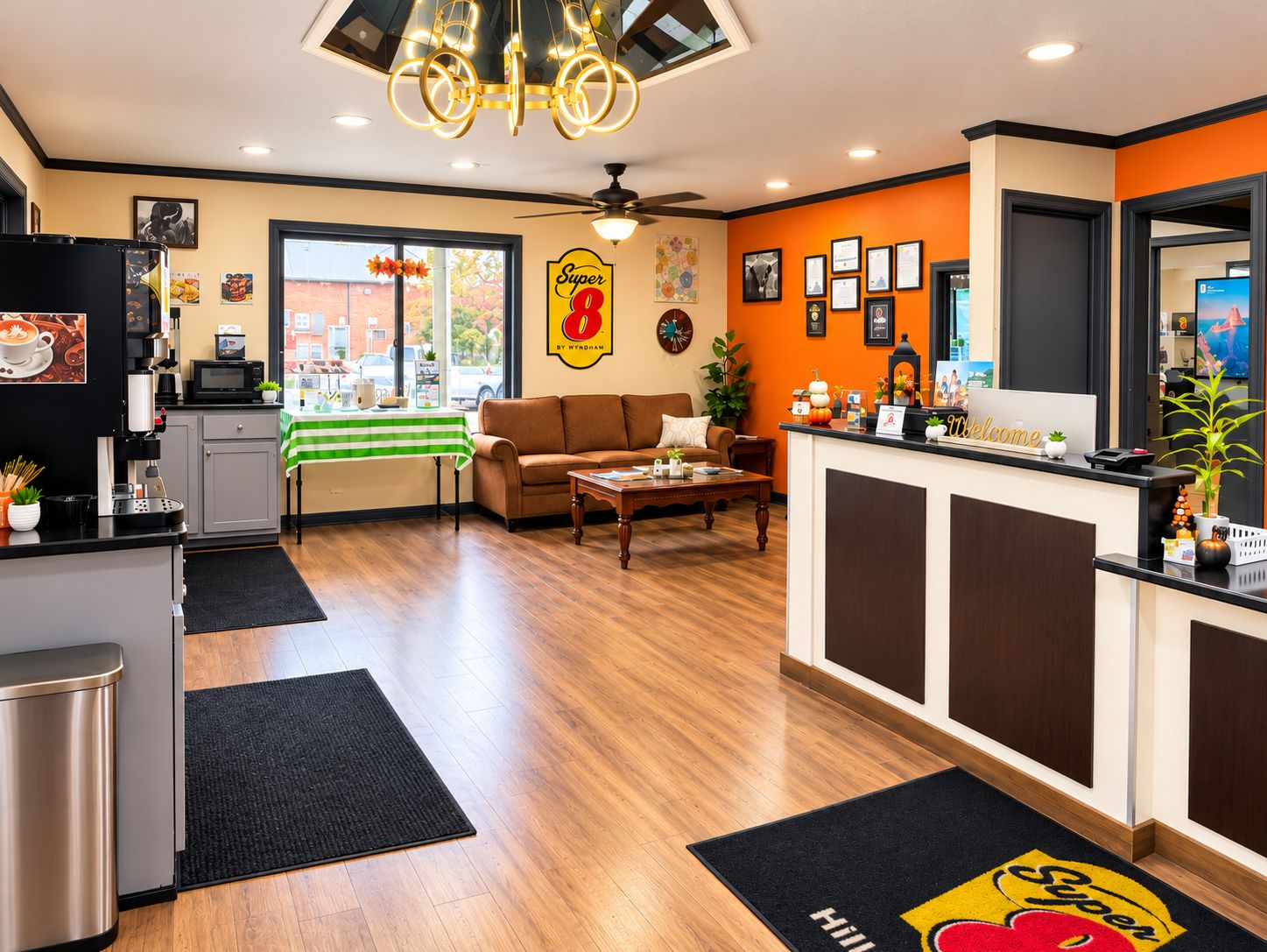 A hotel lobby with a reception desk, a sofa, a coffee station, and a view of the street.