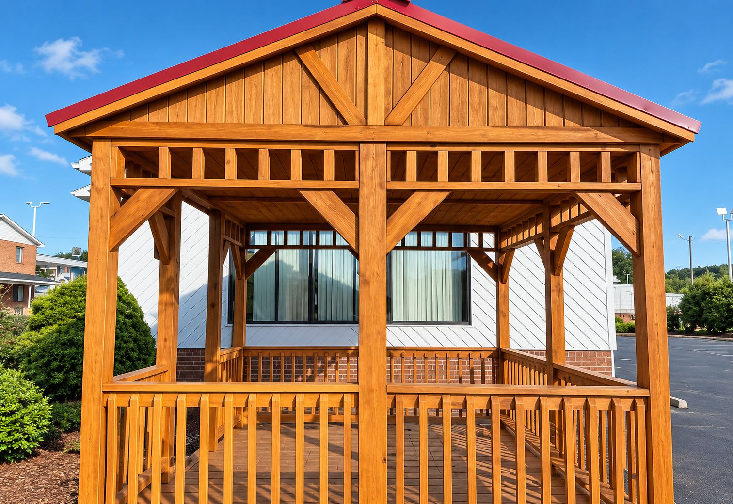 A wooden gazebo with a red roof, a brick base, and a wooden railing.
