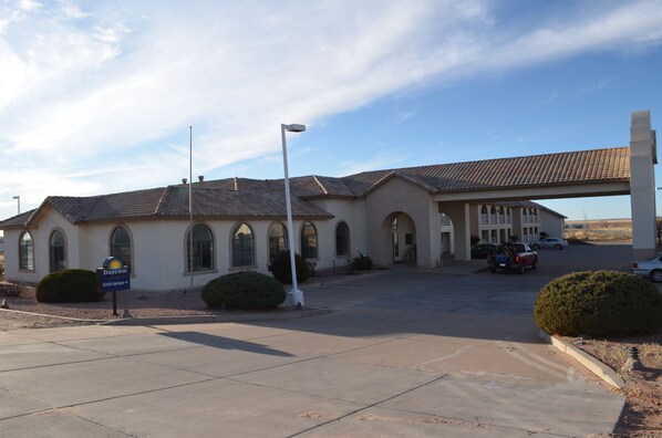 A Days Inn with a tiled roof, arched windows, and a covered parking area.